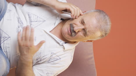 Vertical-video-of-Old-man-getting-bad-news-on-the-phone-gets-upset.
